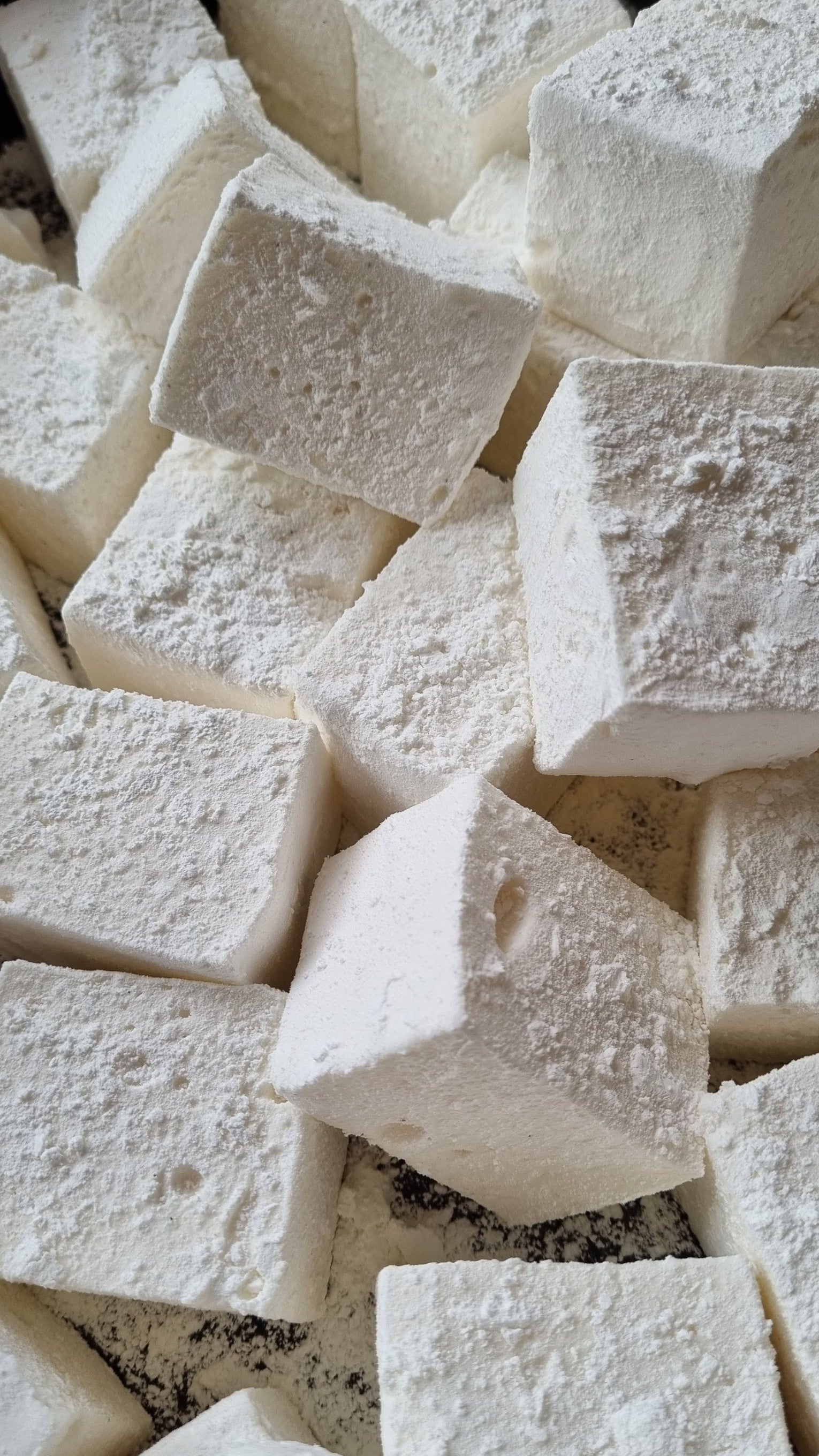 Close-up of white vanilla marshmallows on a marble surface