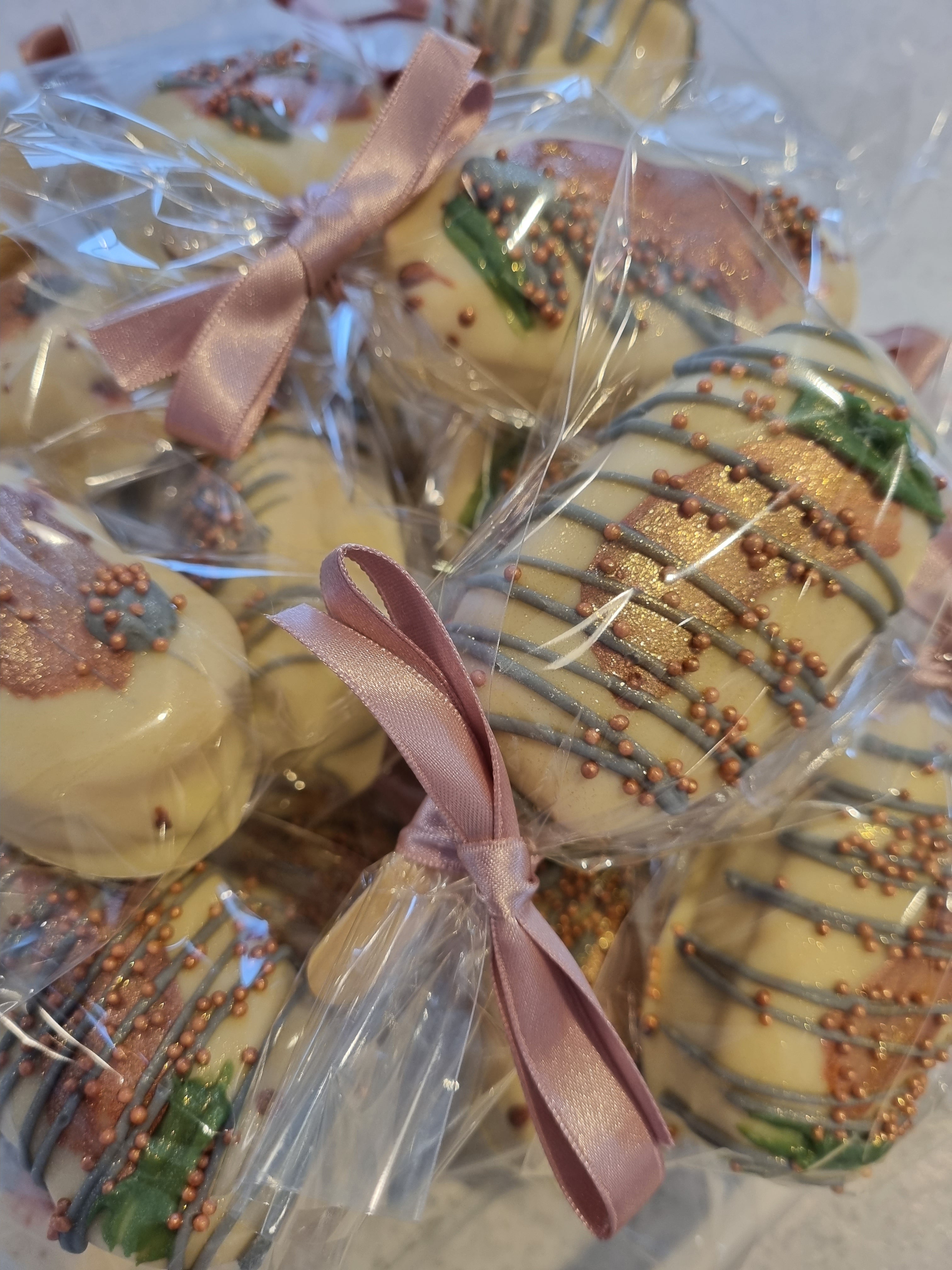 Decorative marshmallow chocolate wedding favours with gold drizzle and pink ribbons on a table